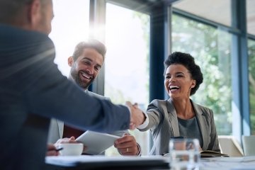 Cropped shot of businesspeople shaking hands during a meeting in an office.
